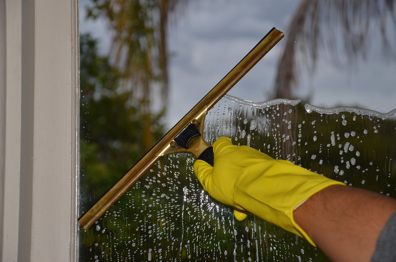 Reinigungsunternehmen reinigt ein Fenster (Glasreinigung)