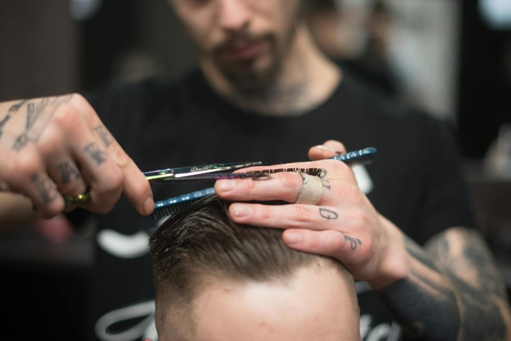 Lokaler Barbershop bei dem eine Person dabei ist Haare zu schneiden.