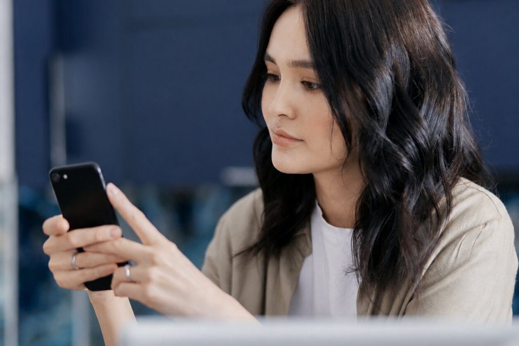 Local SEO, AI-SEO für Gebäude- & Immobilienservices - Frau mit einem Smartphone in der Hand.